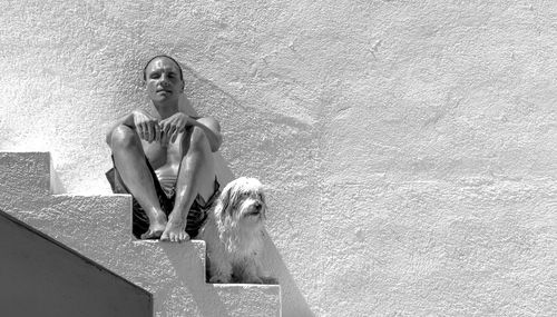 Portrait of man sitting outdoors with dog