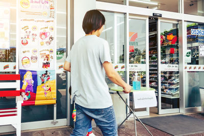 Rear view of woman standing at store