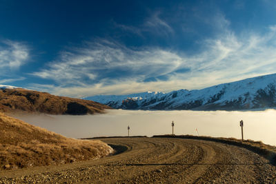 Road leading towards mountains against sky