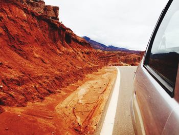 Road by mountain against sky