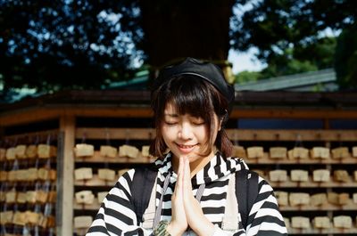 Smiling woman with hands clasped