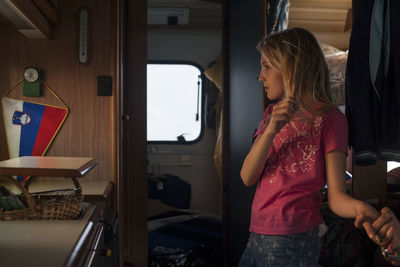 Cropped image of woman holding girl hand standing in motor home