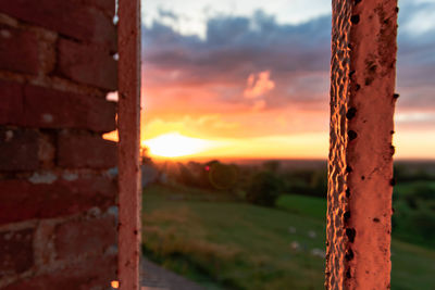 Close-up of metal against orange sky