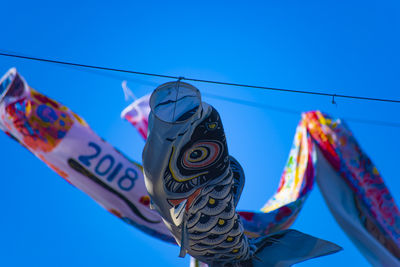 Low angle view of kite against clear blue sky