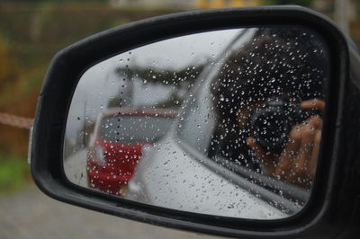 Close-up of raindrops on side-view mirror