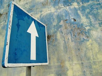 Close-up of arrow sign on wall