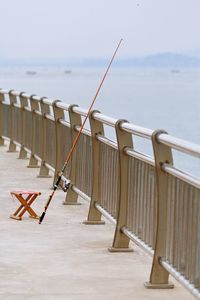 Close-up of fishing rod against railing