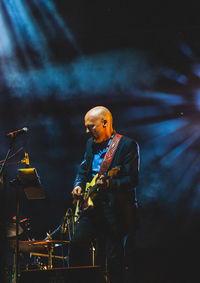 Man with illuminated lighting equipment at night