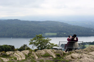 Rear view of couple overlooking calm lake