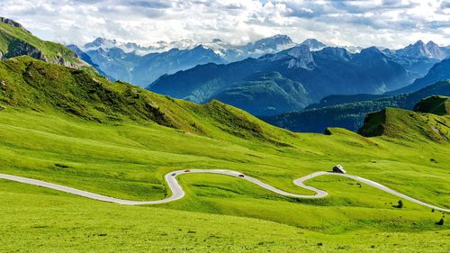 Scenic view of green landscape and mountains against sky