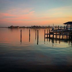 Pier in sea at sunset