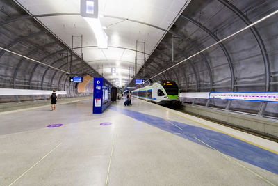 Rear view of man walking on railroad station