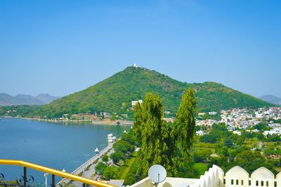 Scenic view of lake and mountains against clear blue sky