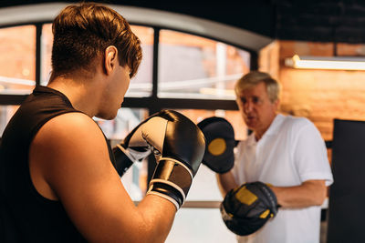 Coach boxing with boxer in  ring