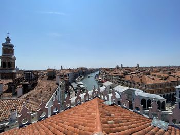 High angle view of buildings in city against clear blue sky