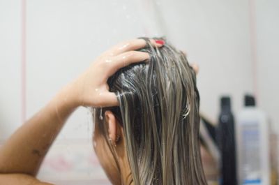 Close-up of woman taking bath in bathroom