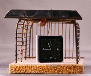 Close-up of clock with metallic equipment on table