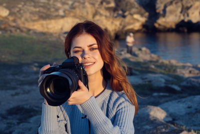 Portrait of smiling young woman standing outdoors