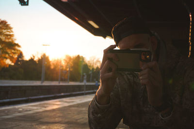 Rear view of man photographing through camera