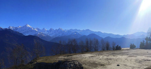 Panoramic view of snowcapped mountains against clear blue sky