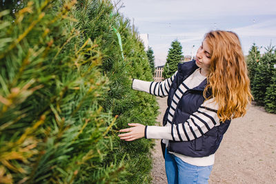 Rear view of woman standing amidst plants