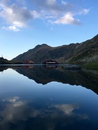 Scenic view of lake by mountains against sky