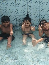 High angle view of shirtless friends in swimming pool