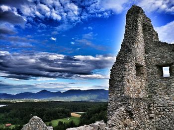 Castle on mountain against cloudy sky