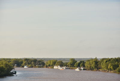 Boats sailing in river against sky