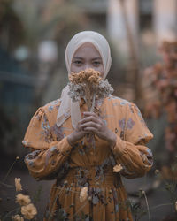 Portrait of woman holding flowers