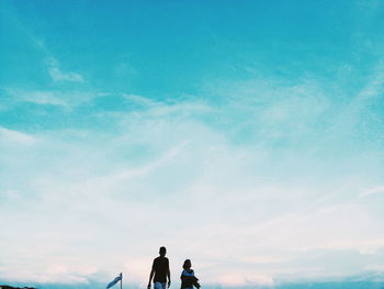 Low angle view of people standing against sky