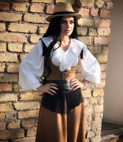 Portrait of a young woman standing against brick wall