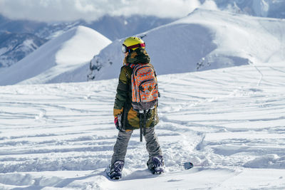 Rear view of person on snowcapped mountain