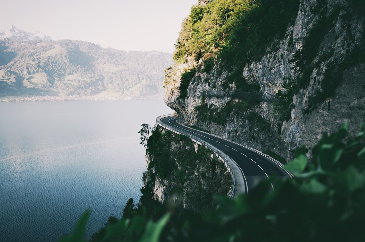 mountain, nature, water, beauty in nature, scenics - nature, transportation, no people, day, plant, sea, tree, tranquil scene, tranquility, sky, non-urban scene, road, mode of transportation, outdoors, rock, formation