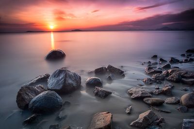 Scenic view of sea against romantic sky at sunset