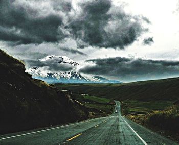 Country road against cloudy sky