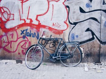 The end of a bicycle in a contemporary urban environment, street, sidewalk, wall, graffiti 