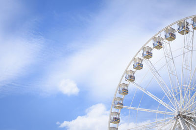 Low angle view of ferris wheel against blue sky