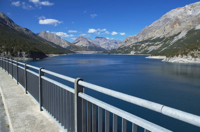 Scenic view of lake and mountains against blue sky