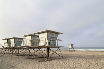 Lifeguard hut on sandy beach against sky