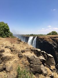 Scenic view of waterfall against sky 