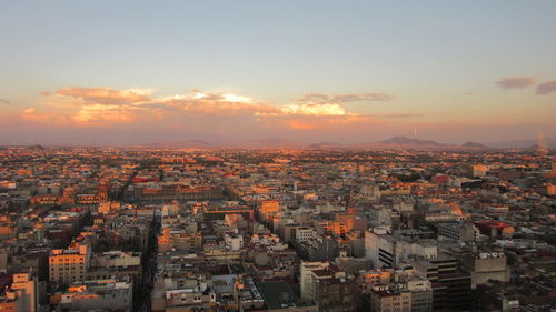 Aerial view of cityscape against sky during sunset