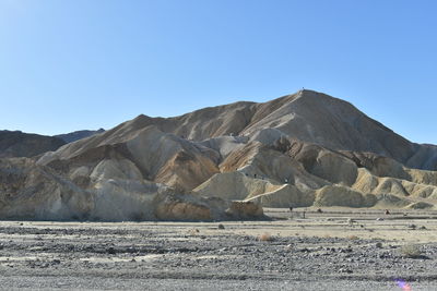 Scenic view of desert against clear blue sky
