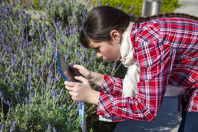 Young woman using mobile phone in farm