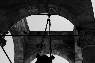 Low angle view of old electric lamp hanging on building