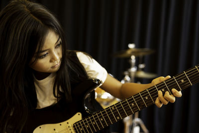 Girl with long hair playing guitar