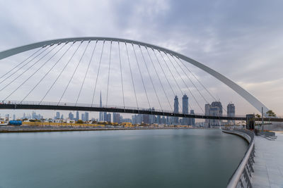 View of bridge over river against sky in city