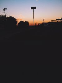 Silhouette of street light against sky at sunset