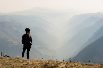 Woman looking at view while standing on mountain