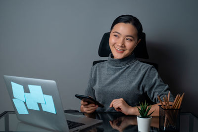 Portrait of smiling woman using mobile phone